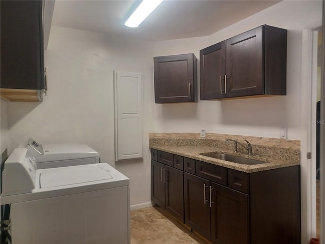 laundry area with separate washer and dryer, a sink, and cabinet space