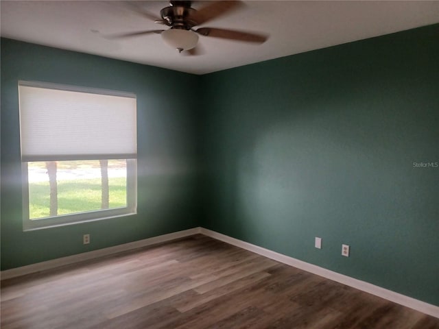 unfurnished room featuring dark wood-type flooring, baseboards, and ceiling fan
