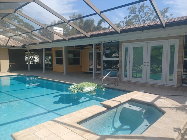 view of swimming pool with ceiling fan, french doors, a patio, a lanai, and a pool with connected hot tub