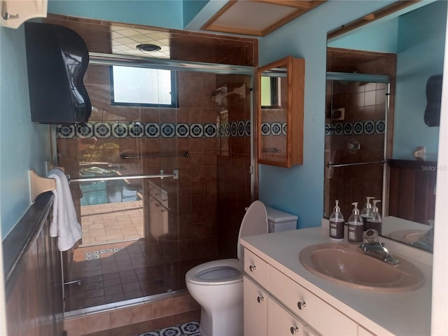 bathroom with a shower stall, toilet, and vanity