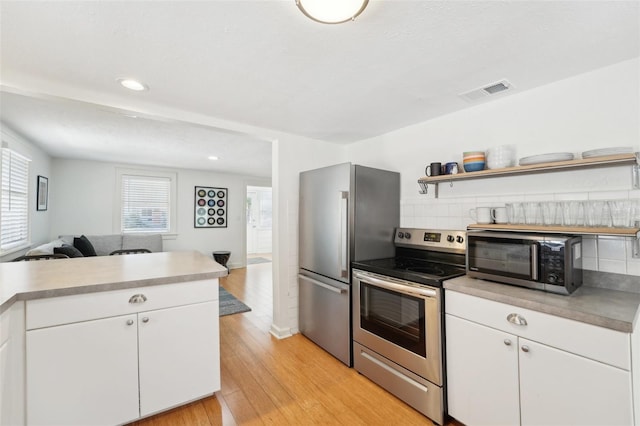3611 4th Ave N, Saint Petersburg, FL 33713 - kitchen featuring light wood-style floors, light countertops, visible vents, and appliances with stainless steel finishes