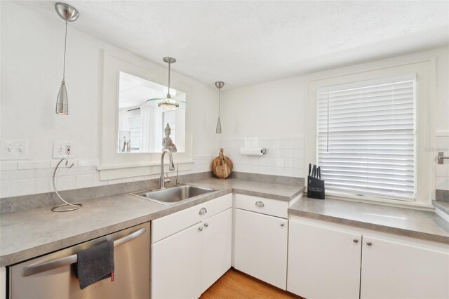 3611 4th Ave N, Saint Petersburg, FL 33713 - kitchen featuring dishwasher, a sink, white cabinetry, pendant lighting, and decorative backsplash