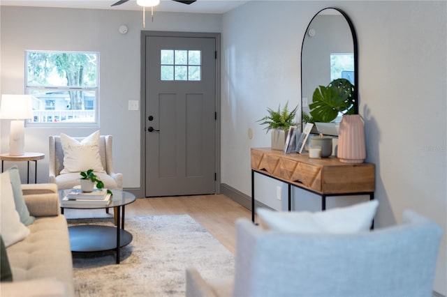 entrance foyer with light wood finished floors, baseboards, and ceiling fan