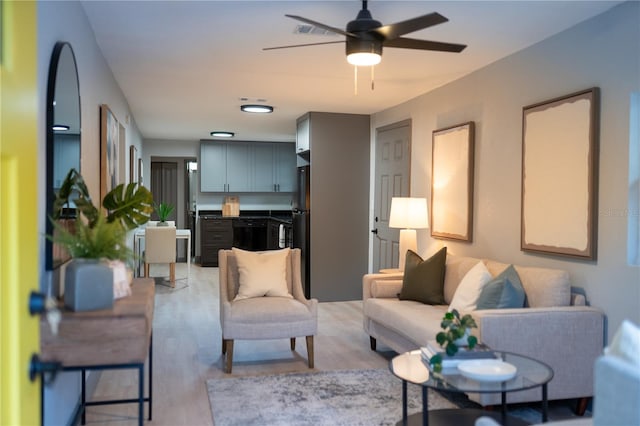 living room with ceiling fan and light wood-type flooring
