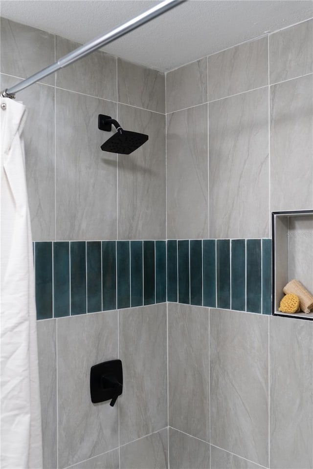 interior details featuring a tile shower