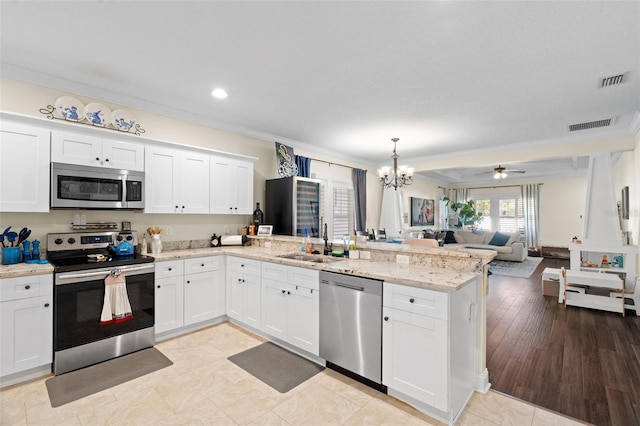1410 25th St N, Saint Petersburg, FL 33713 - kitchen with a sink, open floor plan, a peninsula, appliances with stainless steel finishes, and visible vents