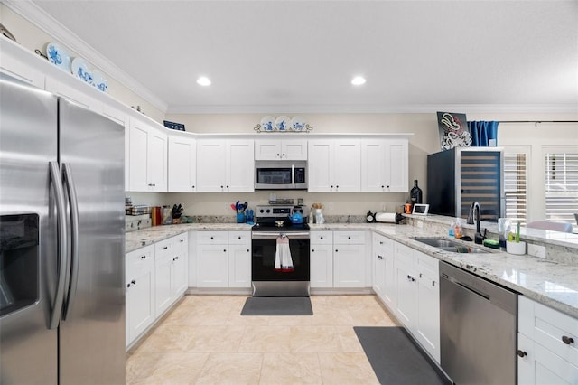 1410 25th St N, Saint Petersburg, FL 33713 - kitchen featuring crown molding, a sink, stainless steel appliances, white cabinetry, and light stone countertops