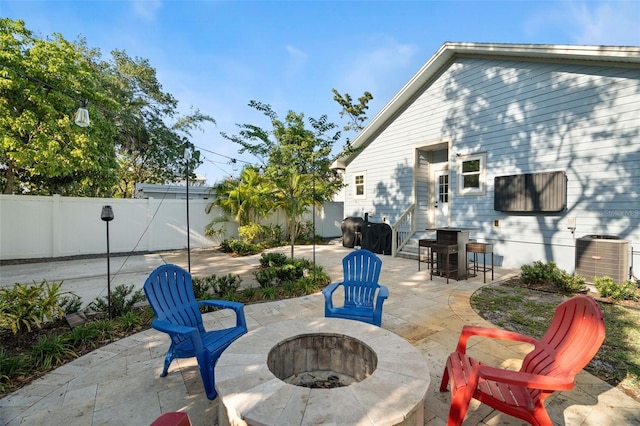 1410 25th St N, Saint Petersburg, FL 33713 - view of patio featuring an outdoor fire pit, fence private yard, and central air condition unit