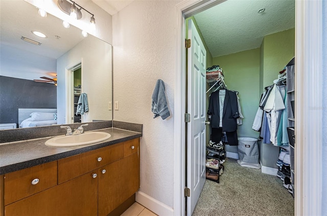 805 100th Ave N, Saint Petersburg, FL 33702 - bathroom with visible vents, a spacious closet, a ceiling fan, and vanity