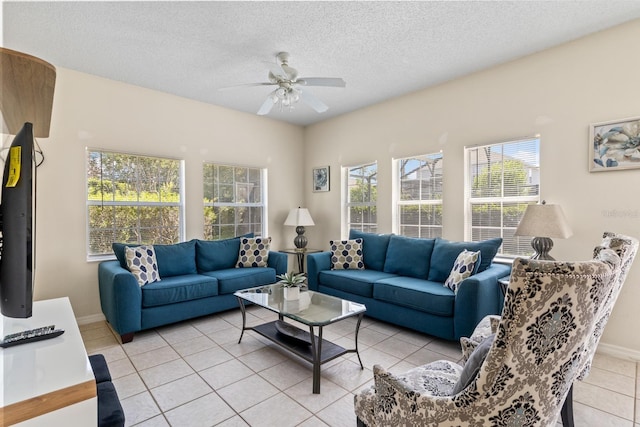 living room featuring a textured ceiling, a ceiling fan, baseboards, and light tile patterned floors