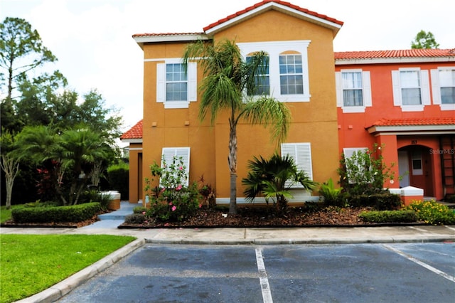 151 Pompano Beach Dr, Kissimmee, FL 34746 - view of front of home with stucco siding, a tiled roof, and uncovered parking