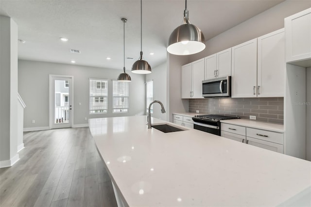 445 31st Way N, Saint Petersburg, FL 33713 - kitchen with a sink, range with gas stovetop, stainless steel microwave, visible vents, and a center island with sink