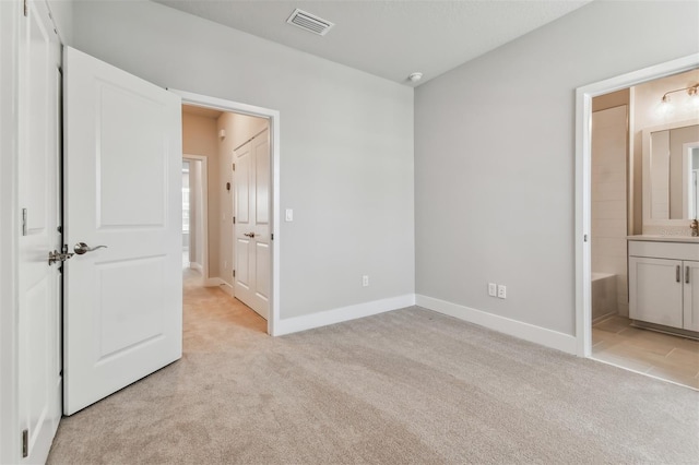 445 31st Way N, Saint Petersburg, FL 33713 - unfurnished bedroom with visible vents, a sink, baseboards, light carpet, and ensuite bath