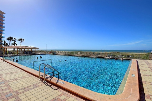 view of pool with a water view and a patio area