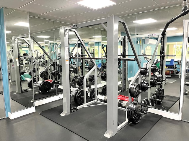 gym with a drop ceiling and a wall unit AC