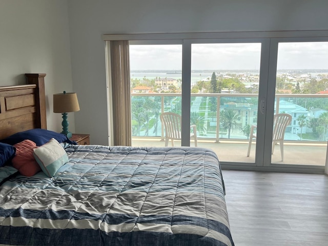 bedroom with access to exterior and wood finished floors