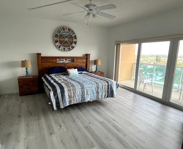 bedroom featuring ceiling fan, access to exterior, a textured ceiling, and wood finished floors