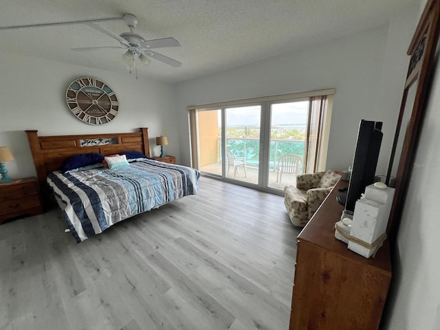 bedroom with access to exterior, a textured ceiling, a ceiling fan, and wood finished floors