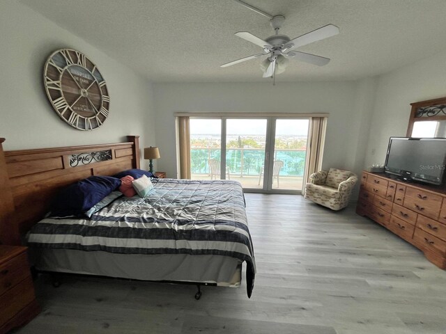 bedroom with access to outside, light wood-type flooring, a textured ceiling, and ceiling fan