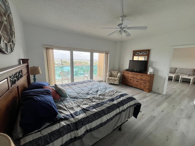 bedroom with a ceiling fan, light wood-style floors, and a textured ceiling