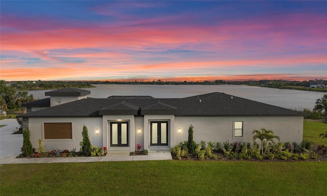 3610 Gulf City Rd, Ruskin, FL 33570 - prairie-style home with stucco siding, a yard, a water view, roof with shingles, and french doors