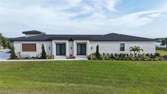3610 Gulf City Rd, Ruskin, FL 33570 - prairie-style house with french doors, a front lawn, and stucco siding