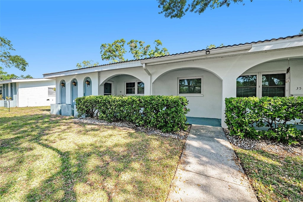 single story home with a front lawn and stucco siding