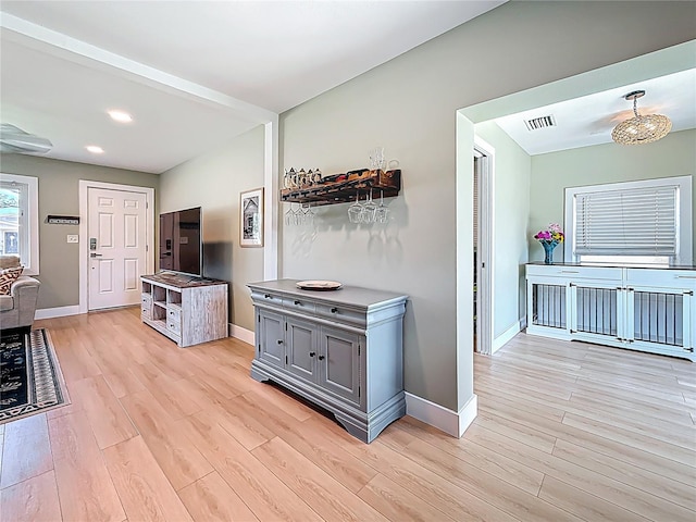 hall with light wood finished floors, recessed lighting, visible vents, and baseboards