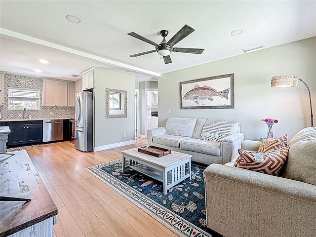 living room with recessed lighting, light wood-type flooring, a ceiling fan, visible vents, and baseboards