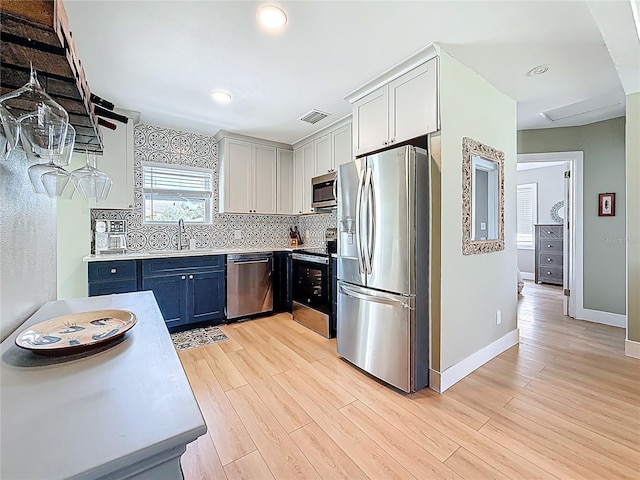 kitchen featuring a sink, light wood finished floors, visible vents, and stainless steel appliances