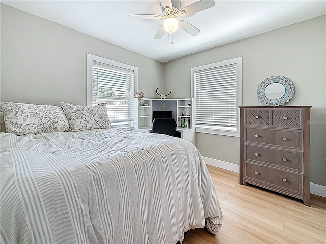 bedroom featuring light wood-style floors, a ceiling fan, and baseboards