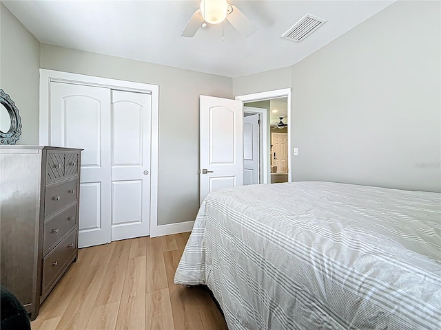 bedroom featuring a closet, light wood-type flooring, a ceiling fan, visible vents, and baseboards