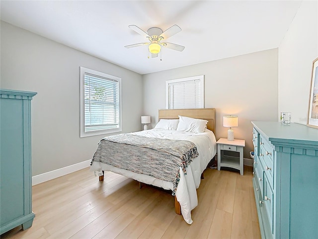 bedroom featuring a ceiling fan, light wood-style flooring, and baseboards