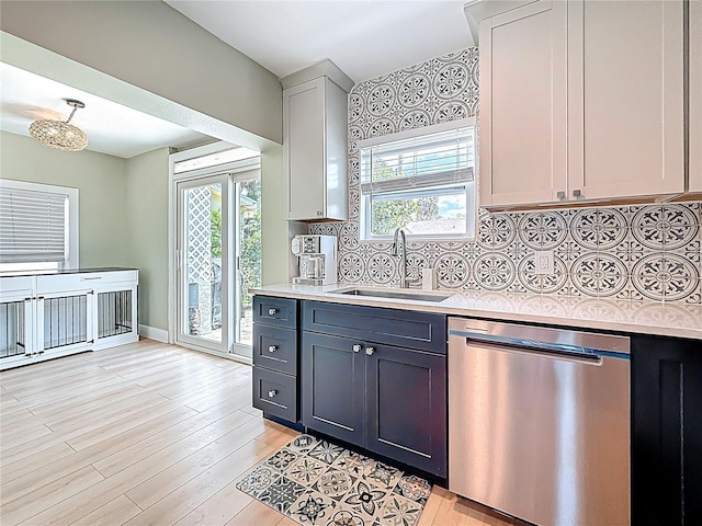 kitchen with a sink, dishwasher, a wealth of natural light, and light countertops