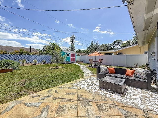 view of patio / terrace featuring a storage shed, outdoor lounge area, an outdoor structure, and a fenced backyard