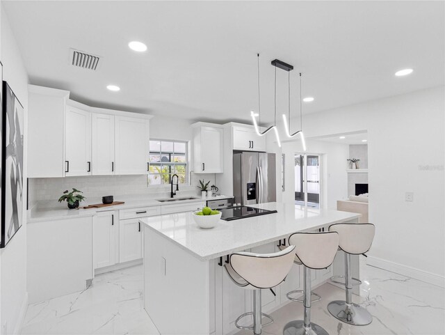 kitchen featuring stainless steel fridge with ice dispenser, visible vents, marble finish floor, and a sink