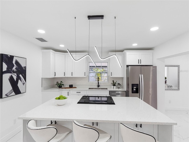 kitchen with visible vents, marble finish floor, a sink, stainless steel appliances, and baseboards