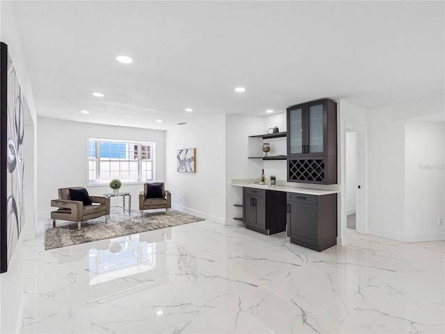 interior space with indoor wet bar, marble finish floor, baseboards, and recessed lighting
