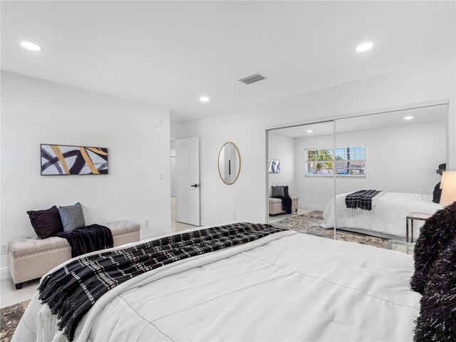 bedroom with a closet, recessed lighting, visible vents, and baseboards