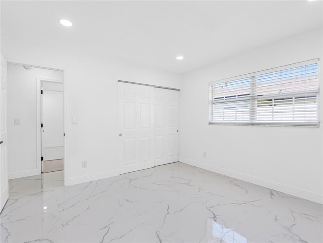 unfurnished bedroom with baseboards, recessed lighting, and marble finish floor