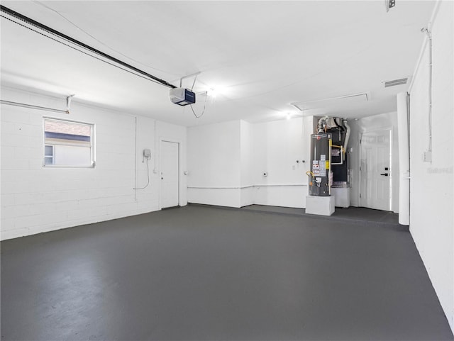 garage with visible vents, a garage door opener, and gas water heater