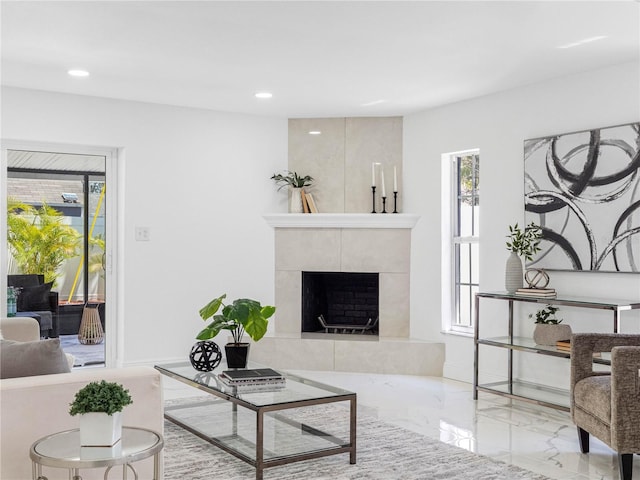 living area featuring recessed lighting, a tile fireplace, and marble finish floor