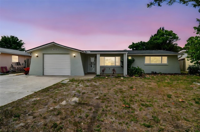 single story home with an attached garage, driveway, and stucco siding
