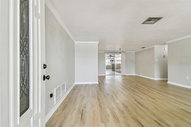 interior space with visible vents, ornamental molding, light wood finished floors, and baseboards