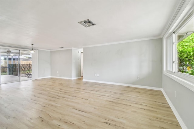 spare room with light wood-style floors, baseboards, ornamental molding, and visible vents