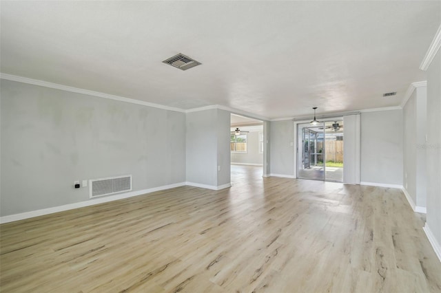 spare room with visible vents, ornamental molding, and light wood-style floors