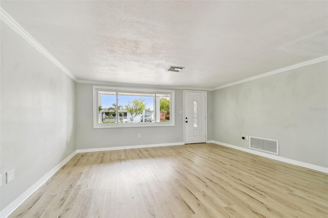 unfurnished living room with crown molding, baseboards, light wood finished floors, and visible vents