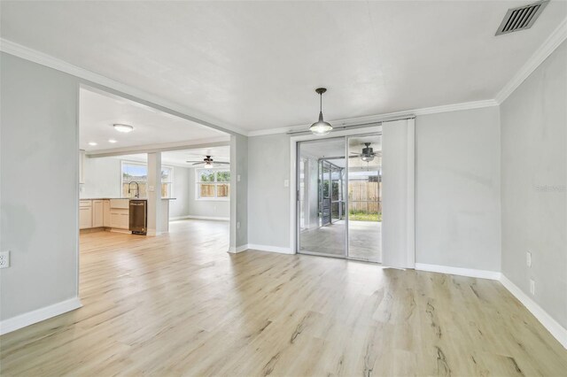unfurnished living room with crown molding, ceiling fan, and visible vents
