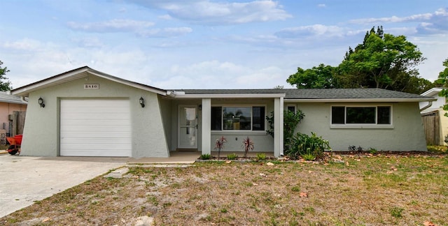 ranch-style house featuring a garage, fence, stucco siding, and concrete driveway