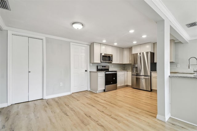 kitchen with light wood-style floors, recessed lighting, baseboards, and stainless steel appliances
